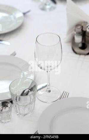 Hochzeit. Bankett. Tisch für Gäste, werden mit Besteck und Geschirr serviert und mit einer Tischdecke bedeckt. Schön gedeckte Tafel mit Gläsern und Tellern Stockfoto