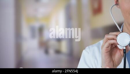 Zusammensetzung des mittleren Abschnitts der Ärztin in der Laborkittel-Holding Stethoskop in einem Krankenhaus ohne Fokus Stockfoto