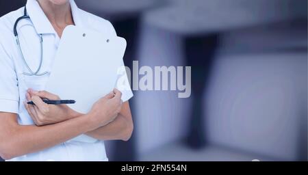 Zusammensetzung des mittleren Abschnitts der Ärztin in der Laborkittel-Holding Zwischenablage über Krankenhaus außerhalb des Fokus Stockfoto