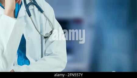 Zusammensetzung der Mittelsektion der Ärztin im Laborkittel mit Stethoskop über Krankenhaus außer Fokus Stockfoto