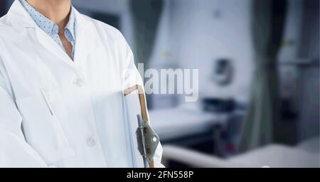 Zusammensetzung des mittleren Abschnitts des männlichen Arztes im Laborkittel mit Zwischenablage über Krankenhaus außerhalb des Fokus Stockfoto