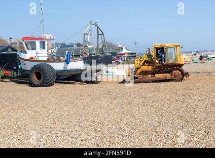 Caterpillar Bulldozer Maschine und Fischerboote auf Kiesstrand, Aldeburgh, Suffolk, England, Großbritannien Stockfoto