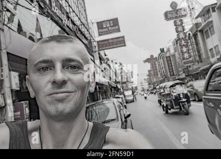 Weltreise Rucksacktouristen in China Town Bangkok, während starker Verkehr. Kannst du jetzt noch in Thailand Rucksack tragen? Stockfoto