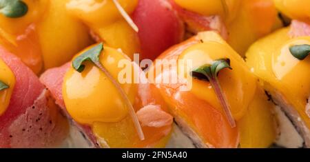 Regenbogen Sushi-Rolle mit Lachs, Thunfisch, Avocado, Königsgarnelen, Frischkäse Philadelphia, Kaviar Tobica, chuka. Sushi-Menü. Japanisches Essen Stockfoto