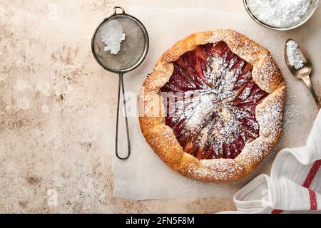 Hausgemachte Rhabarber-Galette mit Sternmuster auf altem Beton-Tischhintergrund. Backvorgang. Öffnen Sie die PIE. Weihnachten und Neujahr Backwaren. Bis Stockfoto