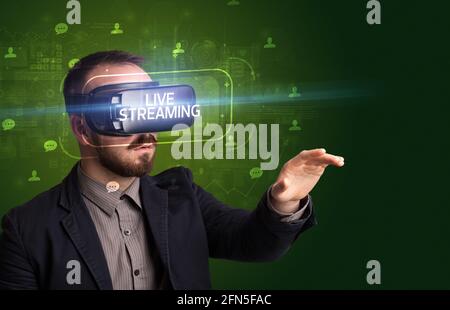 Geschäftsmann schaut durch Virtual Reality Brille, Social-Media-Konzept Stockfoto