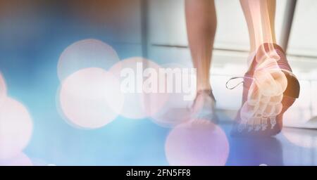 Zusammensetzung von Lichtpunkten über der Frau, die auf dem Laufband läuft Mit Fußknochen Stockfoto