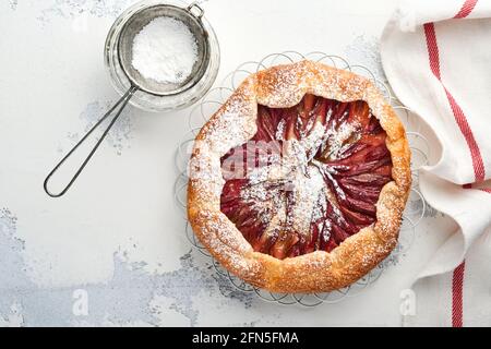 Hausgemachte Rhabarber-Galette mit Sternmuster auf altem Beton-Tischhintergrund. Backvorgang. Öffnen Sie die PIE. Weihnachten und Neujahr Backwaren. Bis Stockfoto