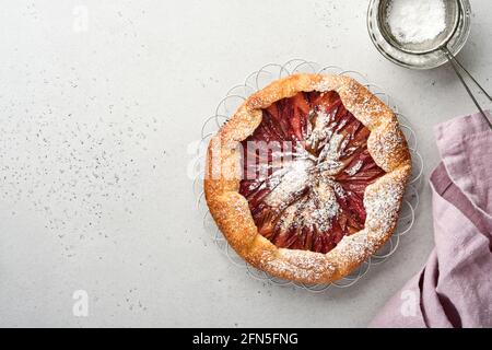 Hausgemachte Rhabarber-Galette mit Sternmuster auf altem Beton-Tischhintergrund. Backvorgang. Öffnen Sie die PIE. Weihnachten und Neujahr Backwaren. Bis Stockfoto