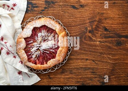 Hausgemachte Rhabarber-Galette mit Sternmuster auf altem Holztisch-Hintergrund. Backvorgang. Öffnen Sie die PIE. Weihnachten und Neujahr Backwaren. Oben Stockfoto