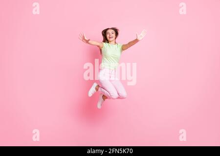 In voller Länge Foto von attraktiven unbeschwerten Dame Hände zu heben Sie springen viel Spaß isoliert auf rosa Hintergrund Stockfoto