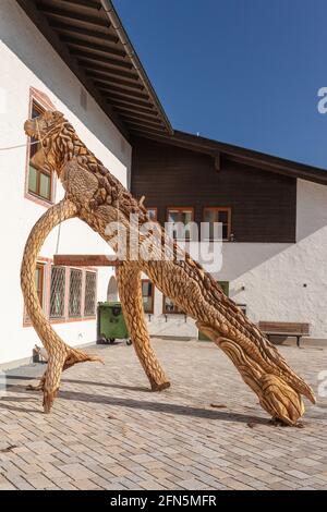 Bad Feilnbach, Deutschland - 25. April 2021: Großer Dinosaurier aus einem Baumstamm geschnitzt Stockfoto