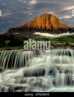 Reynolds Creek mit Spring Wasserfall am Creek bei Sonnenuntergang. Glacier National Park, Montanna Stockfoto