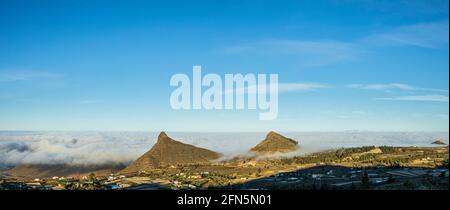 Roque del Conde unter den Wolken, Roque Imoque und Roque de Los Brezos über dem Dorf Ifonche in Adeje, Teneriffa, Kanarische Inseln, Spanien Stockfoto