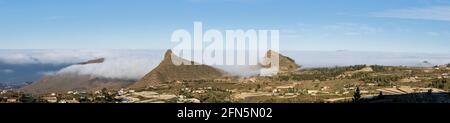 Roque del Conde unter den Wolken, Roque Imoque und Roque de Los Brezos über dem Dorf Ifonche in Adeje, Teneriffa, Kanarische Inseln, Spanien Stockfoto