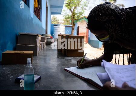 Das Coronavirus ist in das ländliche Indien eingedrungen. Als Quarantänezentrum in einer Dorfgrundschule erhalten die Schüler am 12./05./2021. In einem nahe gelegenen Haus der Schule im Dorf Nabin Nagar, Tehatta, Westbengalen, Indien, Schuhe, die die Regierung von Westbengalen jährlich als Schuhe verteilt. Die Schuhe der Studenten wurden ihren Eltern aufgrund der Bedrohung durch das Coronavirus in Indien übergeben. Die meisten von ihnen sind Wächter, die Analphabeten sind und unterhalb der Armutsgrenze liegen. Das Programm wird mit Vorsichtsmassnahmen vor dem Virus durchgeführt, wie soziale Distanz mit der Verwendung von Hand-Desinfektionsmittel. (Foto von Soumyabra Stockfoto