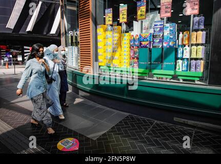 Muslimische Frauen tragen Gesichtsmasken als Vorsichtsmaßnahme gegen die Ausbreitung des Coronavirus, die am zweiten Tag der Hari-Raya-Feierlichkeiten an einem Apothekengeschäft vorbeilaufen sehen.der malaysische Premierminister Muhyiddin Yassin, Hat bekannt gegeben, dass ganz Malaysia vom 12. Mai bis zum 7. Juni 2021 unter den Movement Control Order (MCO) gestellt wird, da Covid-19-Infektionen zunehmen. (Foto von Wong Fok Loy / SOPA Images/Sipa USA) Stockfoto