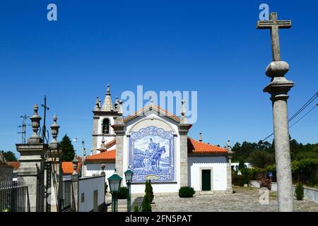 Steinkreuz auf Säule und Keramikfliesen / Azulejos an der Rückwand der Kirche San Martinho, Dorf Freixieiro de Soutelo, Provinz Minho, Portugal Stockfoto