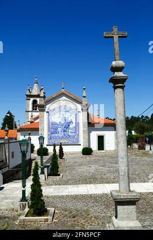 Steinkreuz auf Säule und Keramikfliesen / Azulejos an der Rückwand der Kirche San Martinho, Dorf Freixieiro de Soutelo, Provinz Minho, Portugal Stockfoto