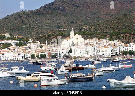 Cadaques, Costa Brava, Nordostspanien. Blick über die mit Booten gefüllte Bucht an einem hellen sonnigen Tag auf die Kirche Santa Maria im Zentrum der Stadt Stockfoto