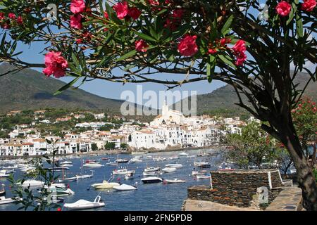 Cadaques, Costa Brava, Nordostspanien. Blick über die mit Booten gefüllte Bucht an einem hellen sonnigen Tag auf die Kirche Santa Maria im Zentrum der Stadt Stockfoto