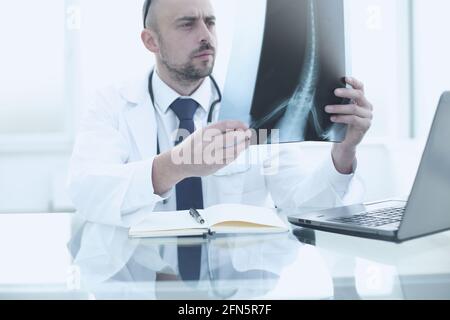 Der Arzt untersucht eine Momentaufnahme der Wirbelsäule des Patienten. Das Konzept der hochwertigen medizinischen Diagnostik Stockfoto