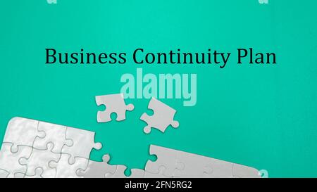 Puzzleteil mit selektivem Fokus und grünem Hintergrund und einer Formulierung für den Business-Continuity-Plan. Geschäftskonzept Stockfoto