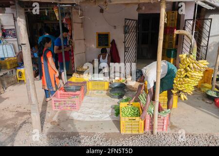 Cuttack, Odisha, Indien - 24. Juli 2019 : Banane und anderes Gemüse werden am Straßenrand verkauft. Der junge Mann arrangiert die Körbe, bevor er sie verkauft Stockfoto