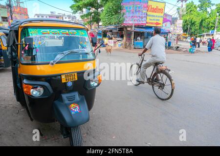 Cuttack, Odisha, Indien - 24. Juli 2019 : Blick auf die Straße der Stadt Cuttack, eine Person, die mit dem Fahrrad und einer Autorikscha fährt, ist neben der Straße geparkt. Stockfoto