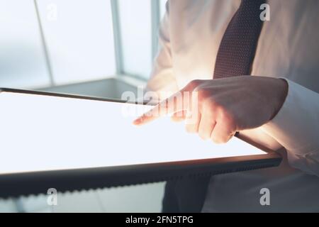 Nahaufnahme EINES Geschäftsmannes, der das digitale Tablet mit Zeigefinger berührt Büro Stockfoto