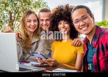 Glückliche multiethnische Gruppe junger Menschen Mitarbeiter Arbeitnehmer mit Laptop in Startup-Studio. Human Resource Business und Teamwork Konzept und Start-up Stockfoto