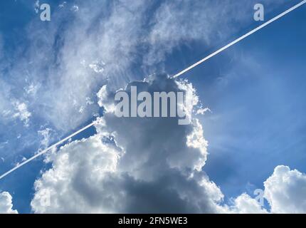 Blick in den blauen Sommerhimmel mit einer Kontrahil-, Zirrus- und Cumuluswolke Stockfoto