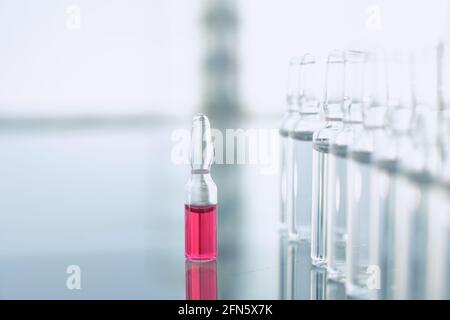 Impfstofffläschchen auf Glastisch in der Arztpraxis. Nahaufnahme Stockfoto