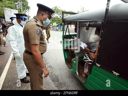 Colombo, Sri Lanka. Mai 2021. Polizisten fordern Passagiere auf, ihre Ausweispapiere in Colombo, Sri Lanka, 14. Mai 2021, vorzulegen. Die srilankischen Behörden haben am Mittwoch erklärt, dass strenge Reisebeschränkungen für die gesamte Insel eingeführt werden, um zu verhindern, dass sich die COVID-19-Pandemie im asiatischen Land weiter ausbreitet. Die landesweiten Reisebeschränkungen traten vom 13. Bis 31. Mai in Kraft. Quelle: Ajith Perera/Xinhua/Alamy Live News Stockfoto