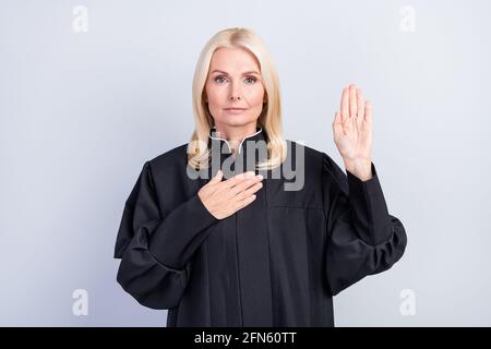 Foto von ernsthaften aufrichtigen alten Frau halten Hand Herz Brust Geben Versprechen Richter Kleidung auf grauem Hintergrund isoliert Stockfoto