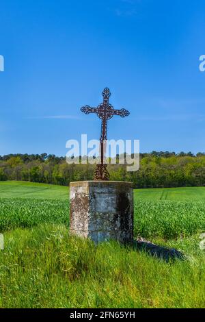 Altes dekoratives Metallkreuz am Straßenrand - Mittelfrankreich. Stockfoto