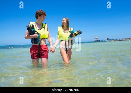 Liebevolles Paar, das im karibischen Ozean spazierengeht Stockfoto