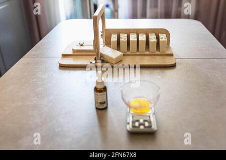 Ein Seifenhersteller wiegt aromatische Öle für die Herstellung von Kosmetika im Küchenmaßstab. Spa im Haus. Kleinunternehmen. Stockfoto