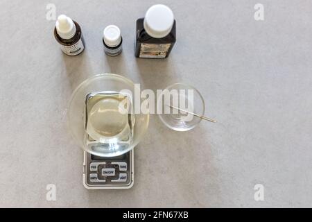 Ein Seifenhersteller wiegt aromatische Öle für die Herstellung von Kosmetika im Küchenmaßstab. Spa im Haus. Kleinunternehmen. Stockfoto