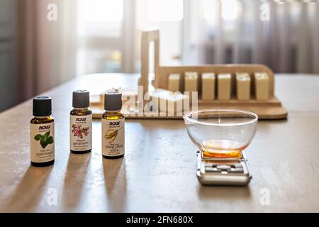 Ein Seifenhersteller wiegt aromatische Öle für die Herstellung von Kosmetika im Küchenmaßstab. Spa im Haus. Kleinunternehmen. Stockfoto