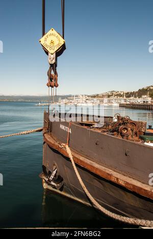 Stillleben an den Docks von Wellington: Historischer Kran, der am Bug eines alten Frachtschiffs im Hafen von Wellington, Neuseeland, hängt. Stockfoto