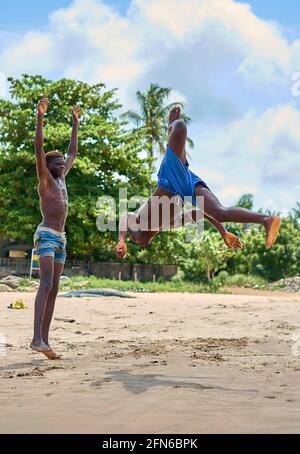 Stone Town, Sansibar, Tansania - Januar 2021: Menschenmassen beobachten, wie junge Menschen auf einem Innenrohr an einem Sandstrand in Stone Town springen. Afrika Stockfoto