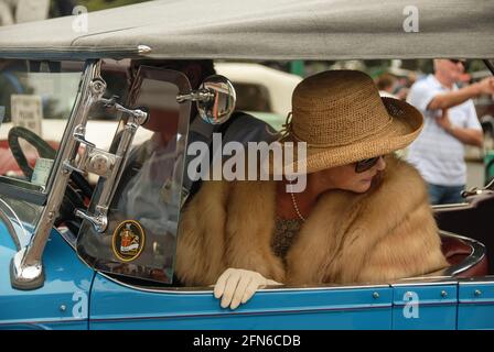 Stilvolles Fahren: Ein Paar, das an der jährlichen Feier während des Art déco-Wochenendes in Napier teilnimmt, gekleidet im Stil der 30s, aber vorsichtig zurücktritt. Stockfoto