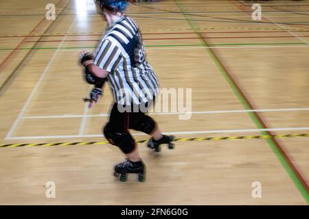 Frau außerhalb der Gleisschiedsrichter beim Skaten auf einem Rollerderby. Stockfoto