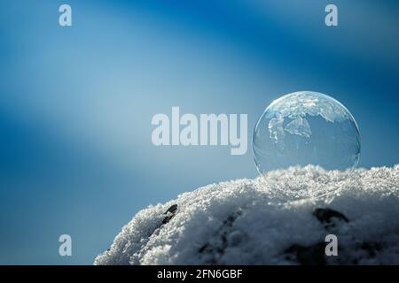 Detailaufnahme einer gefrorenen Seifenblase auf Schnee Stockfoto