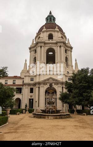 Pasadena, CA, USA - 11. Mai 2021: Beigefarbener Hauptturm aus Stein mit Kuppel und Brunnen vor dem sandigen Innenhof und grünem Laubgarten der historischen Stadt Stockfoto