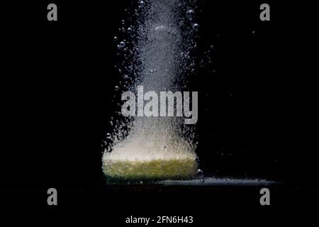 Brausetablette im Wasser auf schwarzem Hintergrund Stockfoto