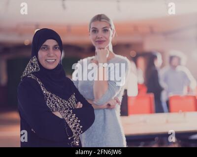 Porträt einer schönen blonden modernen muslimischen Geschäftsfrau, die die Kamera anschaut. Mitarbeiter vielfältiges Team im modernen Freiraum-Büro im Hintergrund Stockfoto