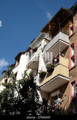 Niedriger Winkel Blick auf ein Wohnhaus mit niedlichen Balkonen und Hängende Blumenkästen Stockfoto