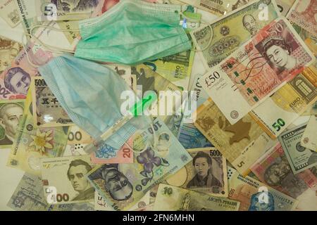 Coronavirus. Geld. Hintergrund. Barrechnungen. Auf dem Hintergrund des Geldes medizinische Maske Thermometer. Stockfoto